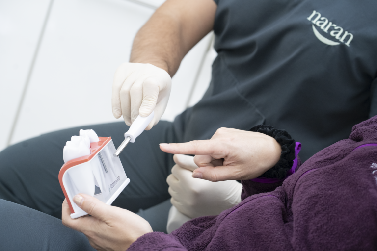 Dentista Clínica Naran explicando a una paciente para qué sirven los implantes dentales