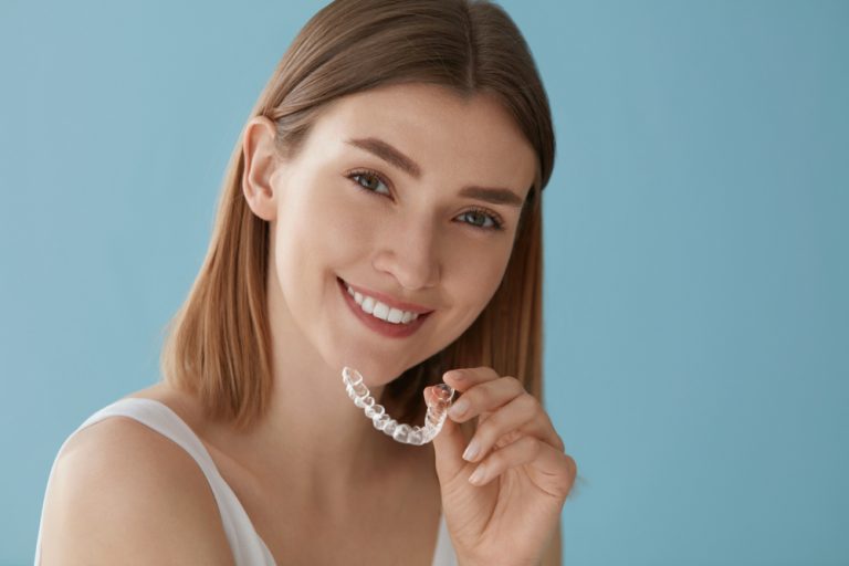 Retrato de mujer joven que tiene un tratamiento de belleza dental con ortodoncia invisible