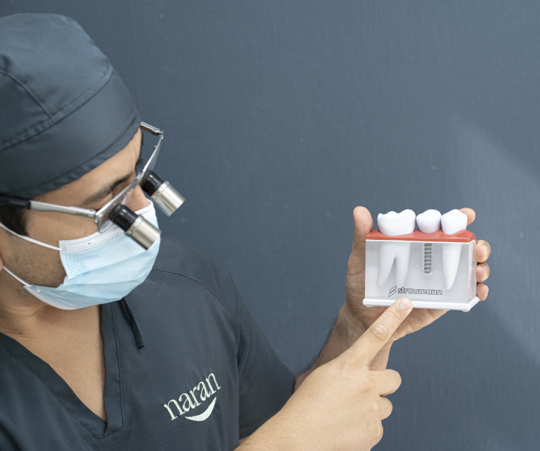 Médico Clínica Naran con modelo educativo explicando qué es un implante dental