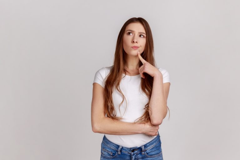 mujer pensando si es mejor usar brackets o alineadores invisibles